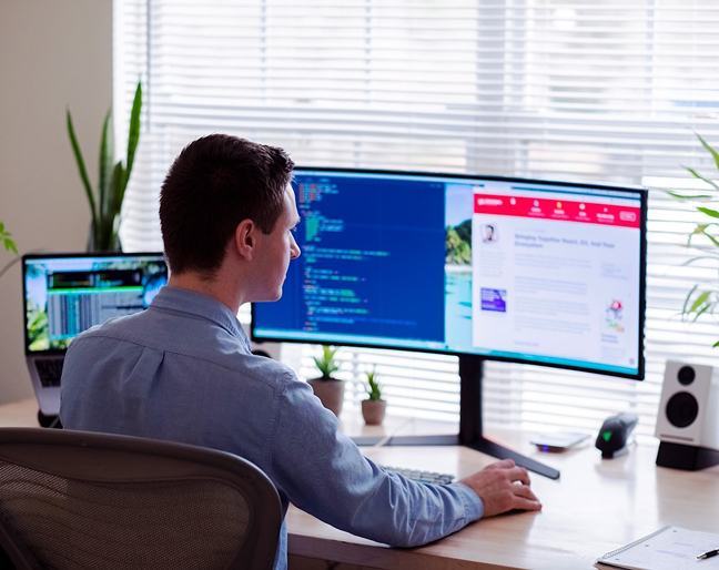 Man looking at dual monitors